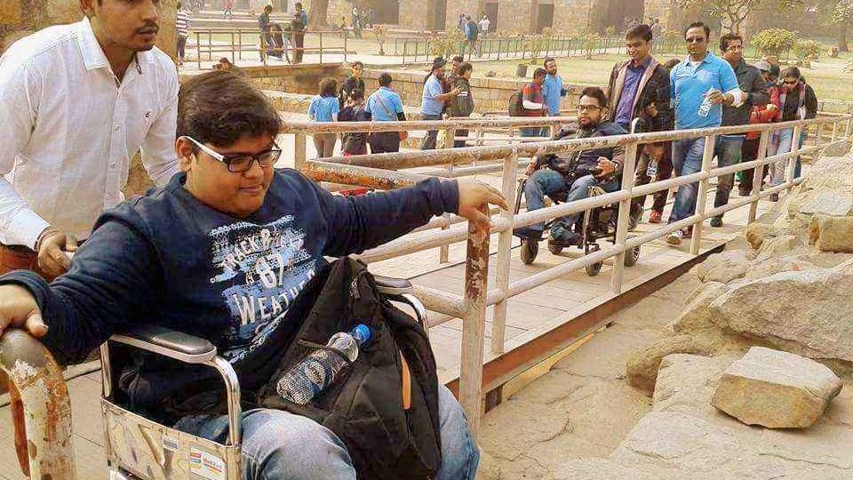 A group including wheelchair users crossing a bridge at a historic site