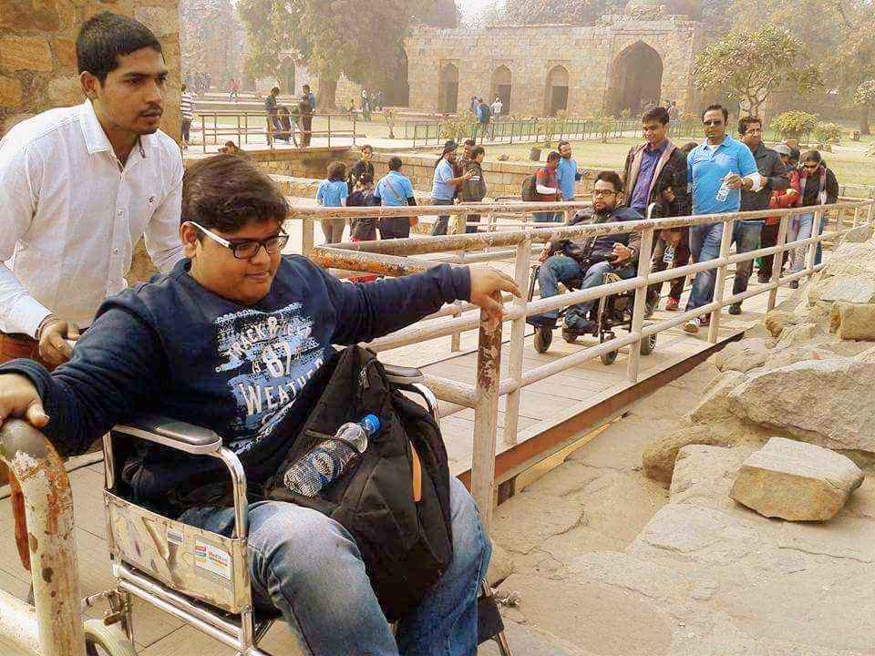 A group including wheelchair users crossing a bridge at a historic site