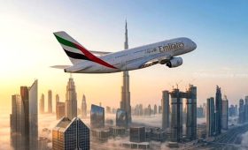 Emirates Airbus A380 flying over the Dubai skyline at sunset