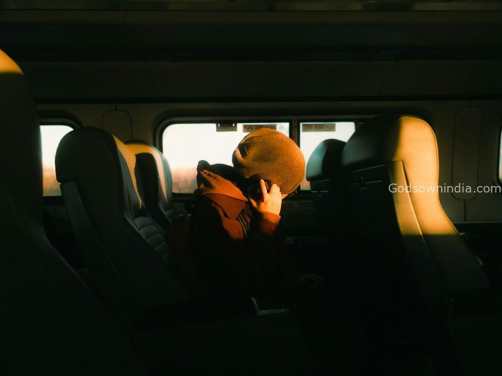 Person sleeping on a train during sunset.
