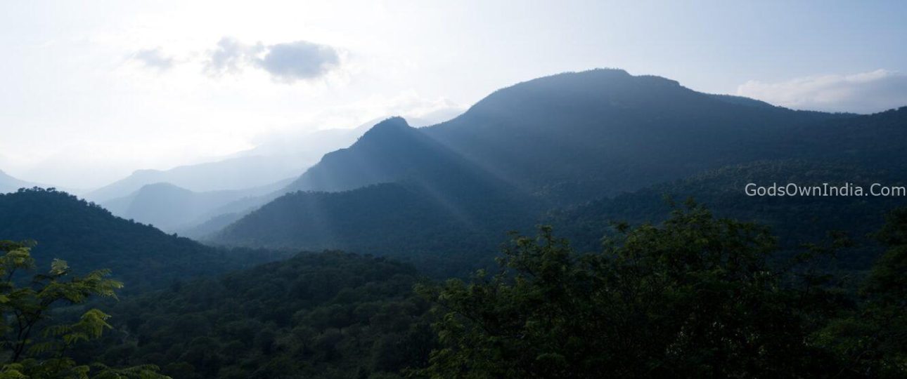 the sun shines on the mountains in the distance