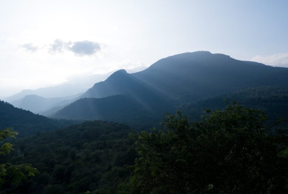 the sun shines on the mountains in the distance