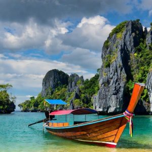 A vibrant, sun-drenched landscape showcasing a traditional Thai longtail boat