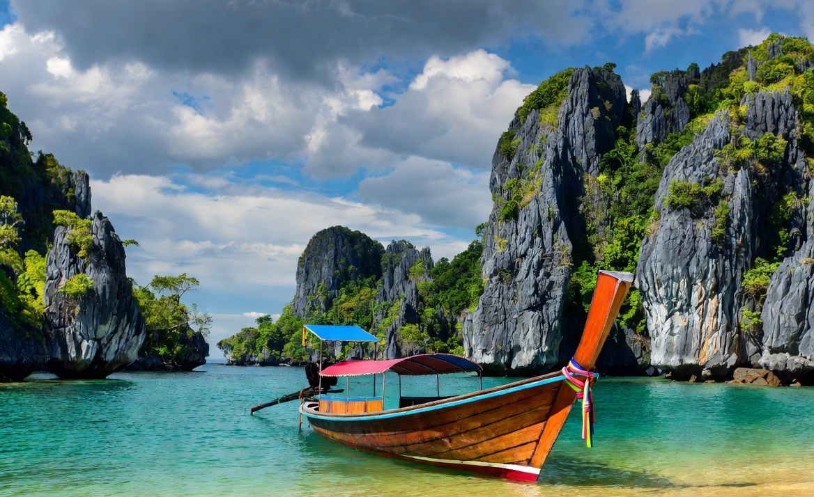 A vibrant, sun-drenched landscape showcasing a traditional Thai longtail boat