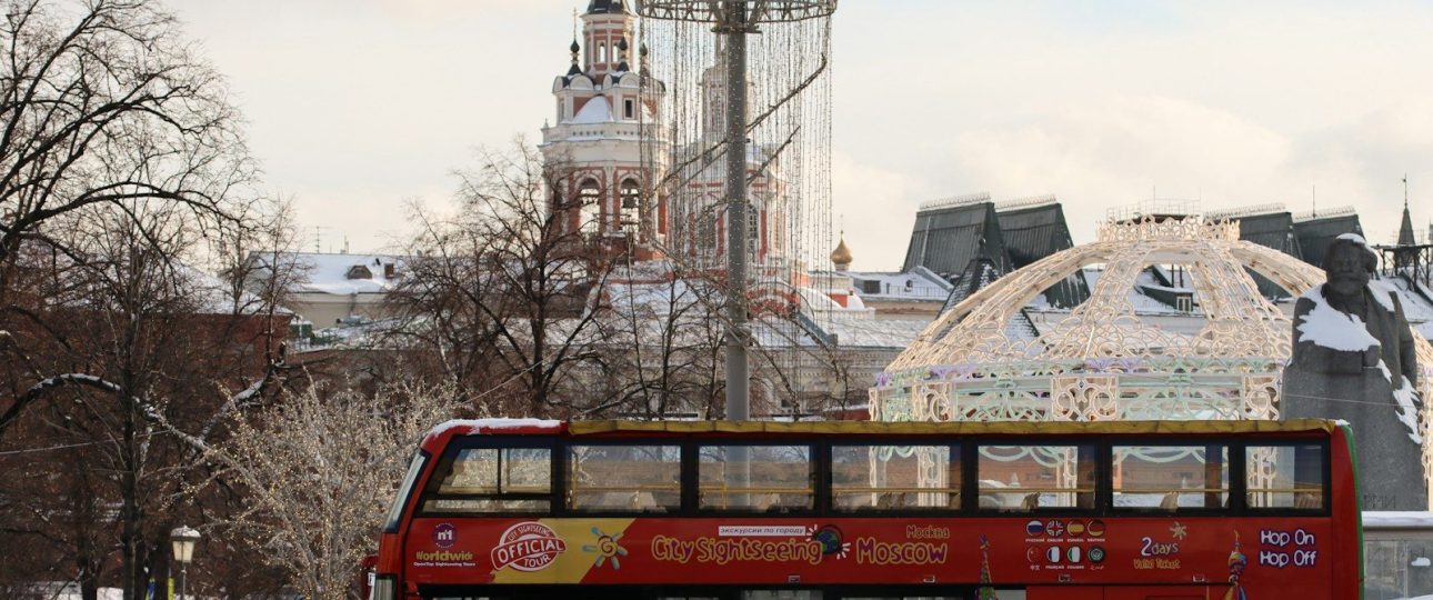 a red double decker bus driving down a street
