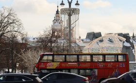 a red double decker bus driving down a street
