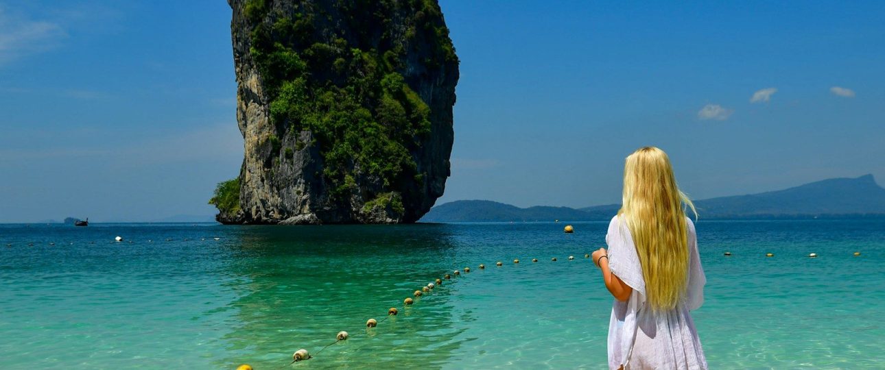 Woman in white dress looks at island in island