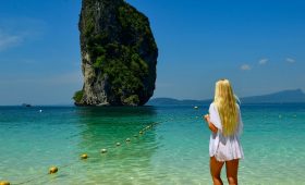 Woman in white dress looks at island in island