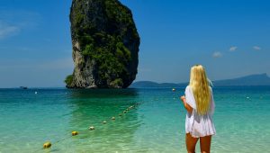 Woman in white dress looks at island in island