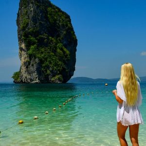 Woman in white dress looks at island in island