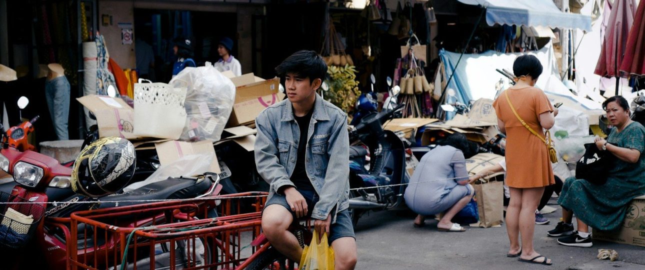 a man sitting on a red cart in front of a store