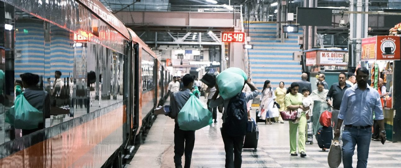 People walking on a busy train station platform.