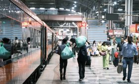 People walking on a busy train station platform.